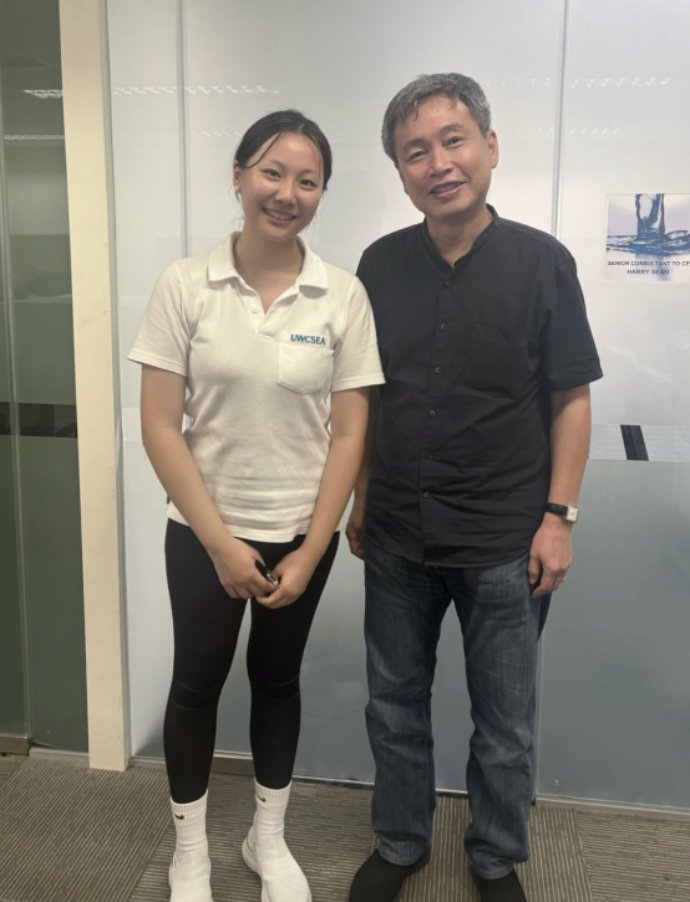 Belle Zhou standing beside Mr Harry Seah outside his office at PUB