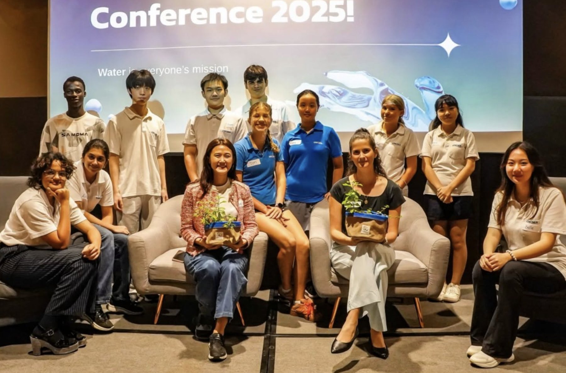 Students, alumni and speakers gathered in front of the United Water Conference 2025 screen